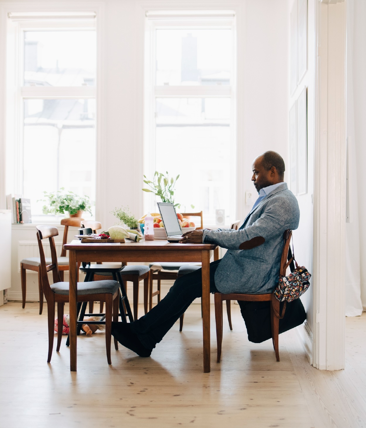 Man working on a laptop in his dining room.